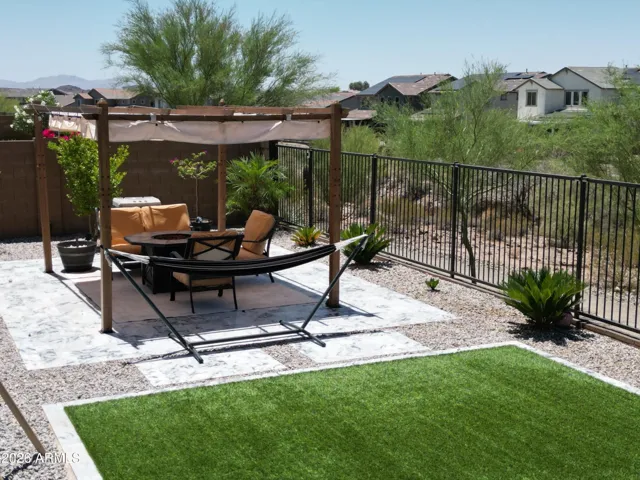 Relax in style against a backdrop of beautiful open space. This view highlights the property's premium view fencing, ensuring your backyard oasis feels connected to the serene desert environment while offering enhanced privacy