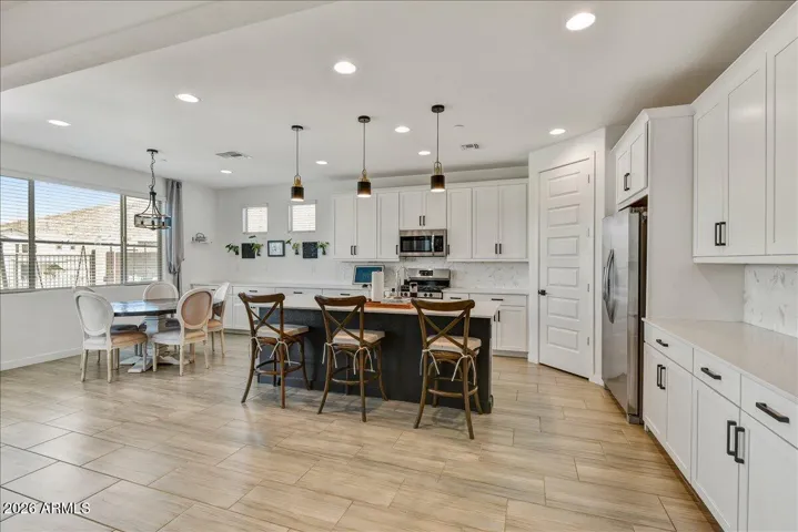 A fantastic wide-angle view highlighting the seamless flow between the dining space and the kitchen. This open-concept layout maximizes natural light and creates a highly connected environment for cooking and entertaining.