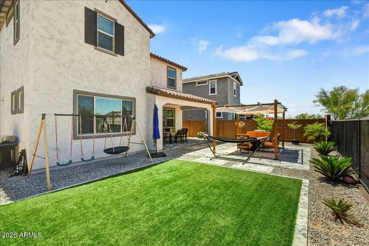 A clear view of the home’s pristine two-story exterior, highlighting the immaculate stucco finish, energy-efficient windows, and a generous yard perimeter. The clean layout maximizes both privacy and usable outdoor space.