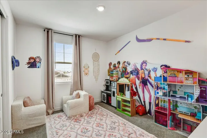 This bright and spacious upstairs bedroom features a large window that let in plenty of natural light. Currently styled beautifully as a vibrant children's play area with a neutral carpet flooring base.