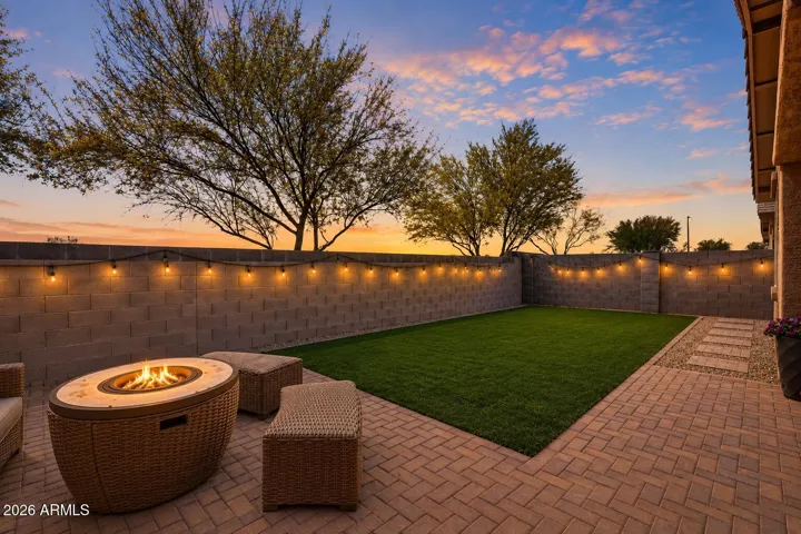 Backyard twilight virtually staged. No neighbors behind. Open desert with sunset and mountain views