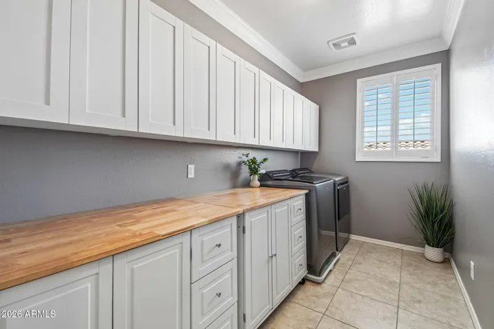 Oversized laundry with built in cabinets and folding tables