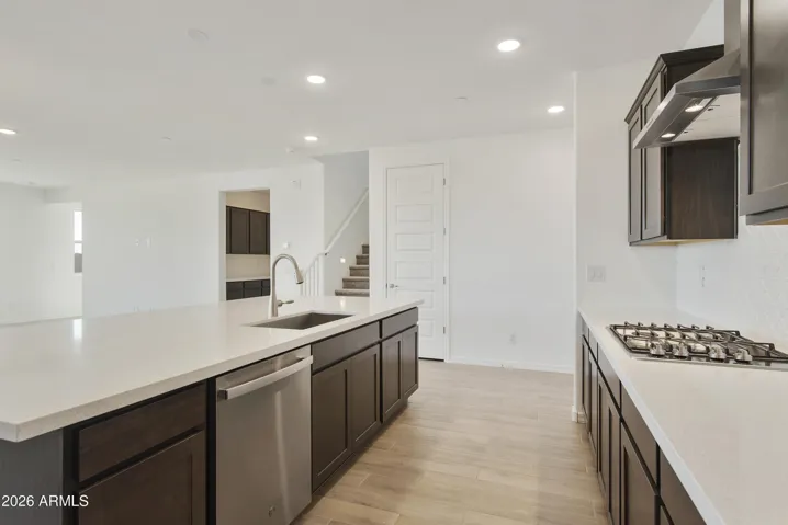 GOURMET KITCHEN WITH BUILT IN APPLINACES. DESIGNER BACKSPLASH, DESIGNER HOOD, GAS COOKTOP AND QUARTZ COUNTERS.