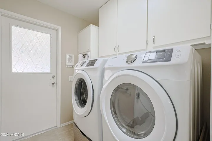 Newer front load Samsung washer and dryer in indoor laundry between garage and kitchen
