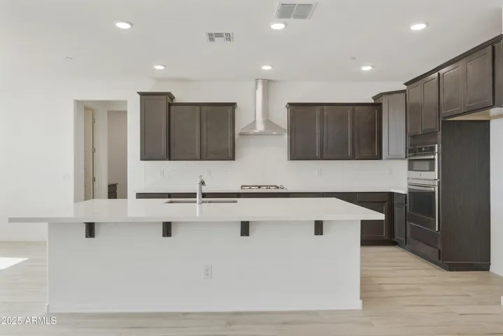 GOURMET KITCHEN WITH GAS COOKTOP, OVEN MICROWAVE COMBO OVEN, DESIGNER HOOD AND UPGRADED CABINETS, COUNTERS AND BACKSPLASHES.
