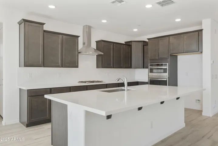 GOURMET KITCHEN WITH GAS COOKTOP, OVEN MICROWAVE COMBO OVEN, DESIGNER HOOD AND UPGRADED CABINETS, COUNTERS AND BACKSPLASHES.