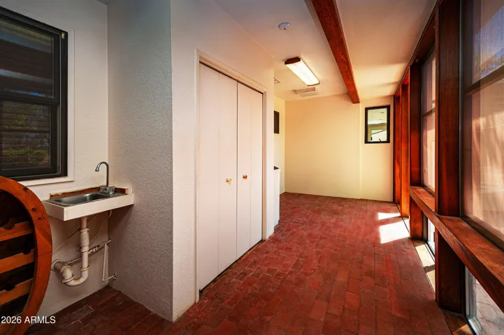 Pantry/utiity room contains sink, water heater, softner hook-up. brick flooring, adjacent to kitchen.