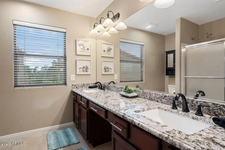 Primary bath with cherry cabinets and beautiful granite tops.