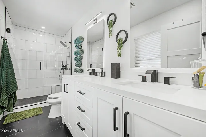 Stunning spa-inspired bathroom with dual sinks, modern fixtures, and oversized tiled shower.