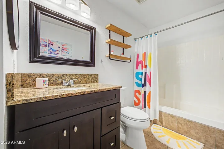 Secondary bathroom with granite counters and updated fixtures.
