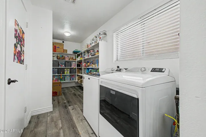 Large laundry room with additional storage shelving and workspace.