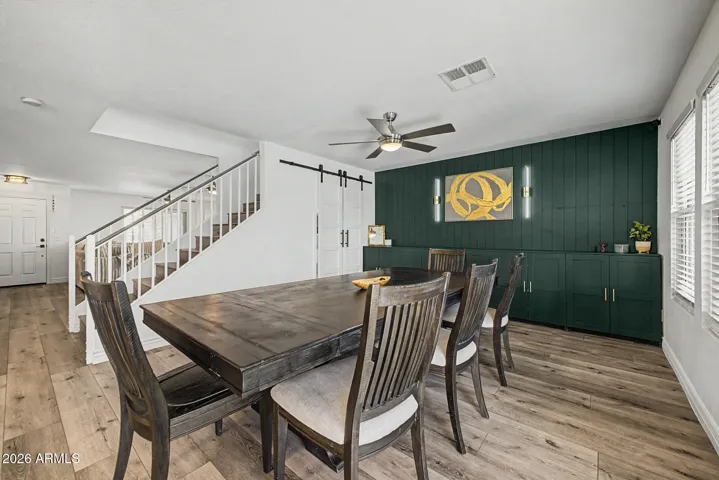 Dramatic accent wall create a stylish entertaining space, while the sliding barn doors lead to a charming playroom or additional storage area tucked beneath the staircase.