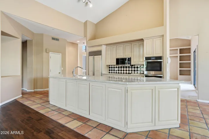 Open plan kitchen with granite countertops, double wall ovens, Subzero refrigerator
