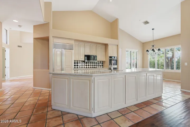 Open plan kitchen with granite countertops, double wall ovens, Subzero refrigerator