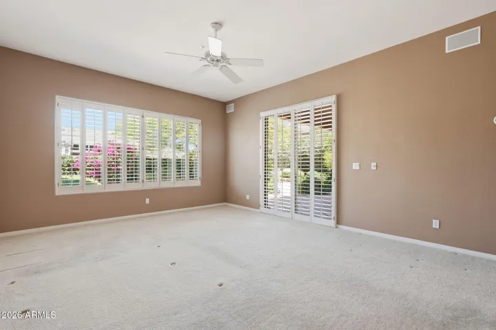 Primary Bedroom - door to rear patio and plantation shutters