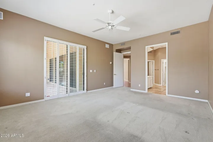 Primary Bedroom - door to rear patio and plantation shutters