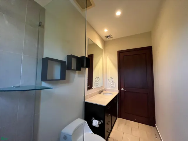 Secondary bedroom's bathroom with wheelchair accesible door.