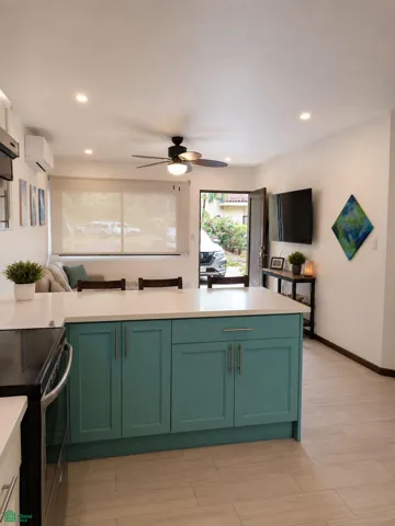 Spacious kitchen island connecting naturally with the furnished living area.