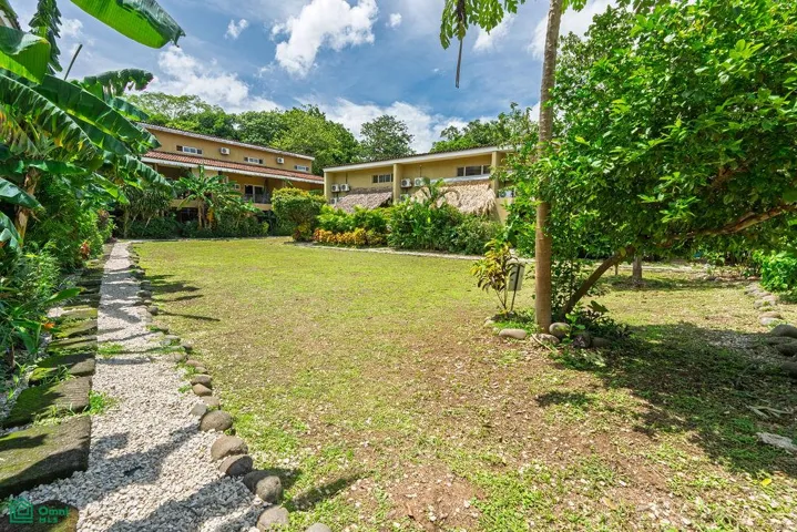 Landscaped green spaces and residential buildings within Cabo Velas Estates.