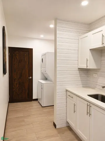 Functional utility area with additional cabinetry, sink and in-unit laundry.