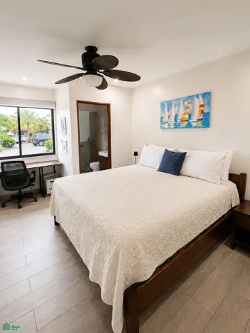 Primary bedroom with workspace and direct access to a full bathroom.