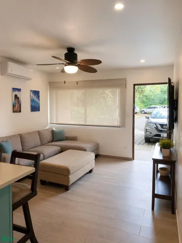Comfortable furnished living room with air conditioning and generous natural light.