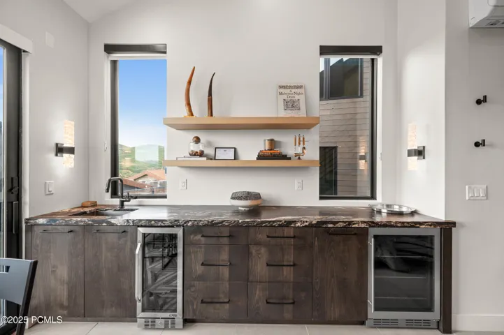 The wet bar features stylish leathered granite and space to store cold beverages.