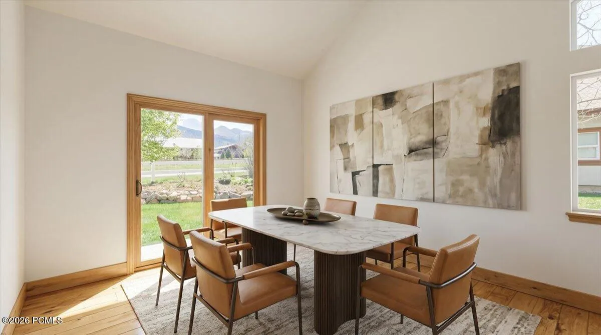 Virtually Staged. Dining Room with Vaulted Ceilings, Hickory Floors and Pella Sliding Glass Door.