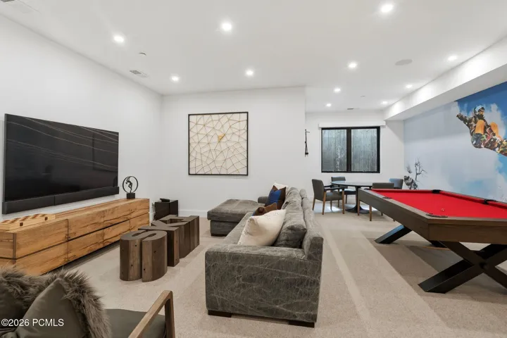 Spacious living room featuring recessed lighting, poker table, pool table, and TV area