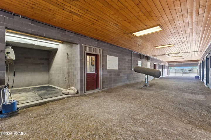 Main Breeding / Veterinary Barn, Attached/connected to the main home; includes indoor wash rack with hot/cold water, stocks, phantom, breeding/veterinary lab, rubber mats, and indoor hot walker. 13 stalls