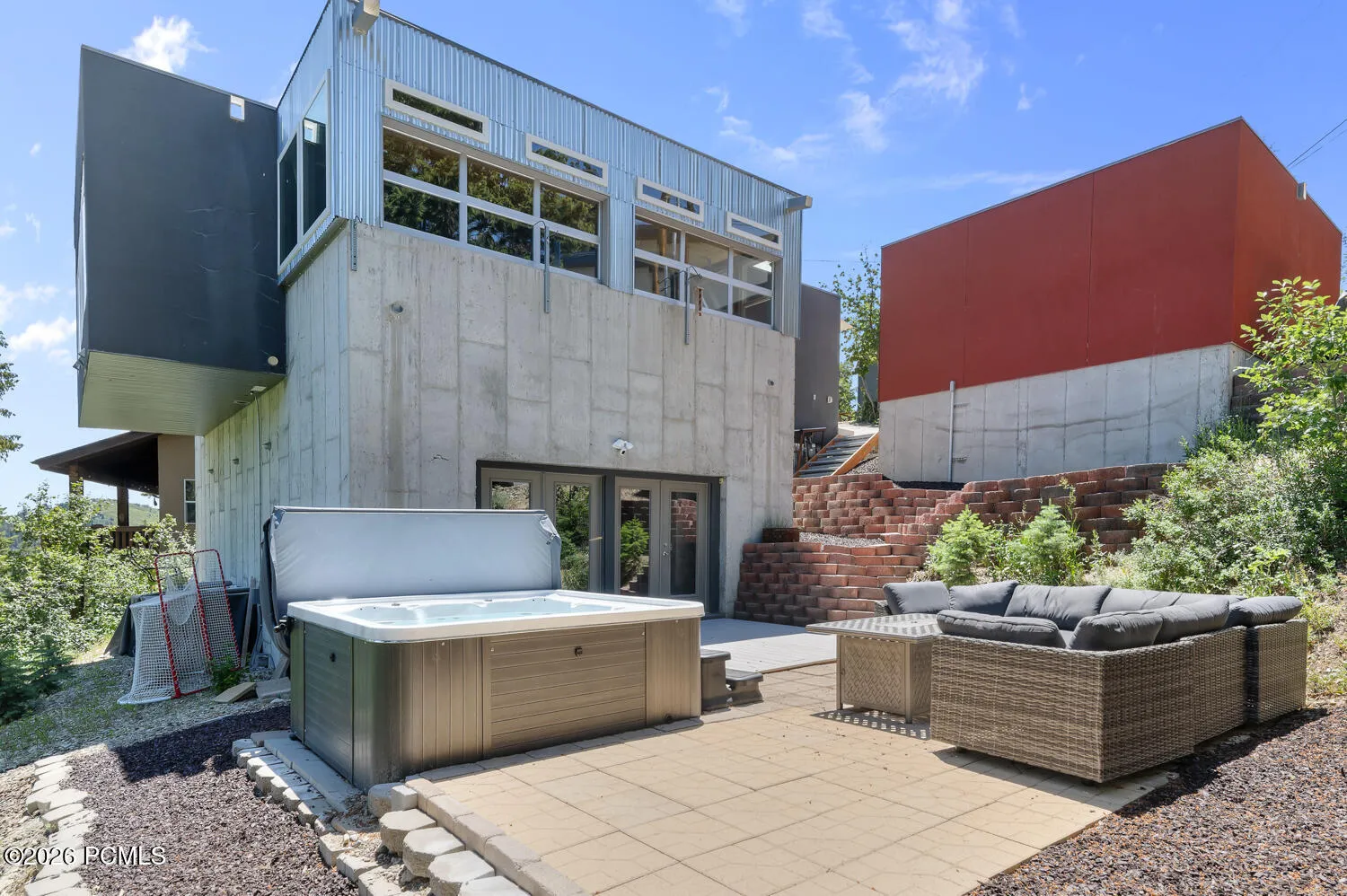 Back patio with hot tub, upper porch area, and garage