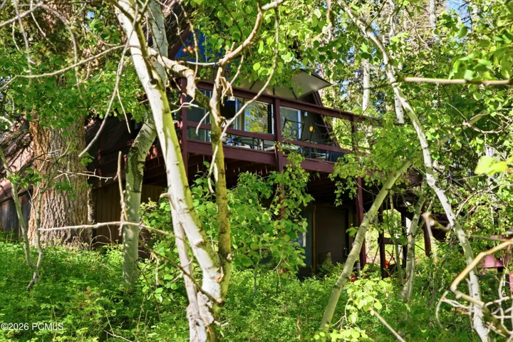A-frame cabin nestled among lush green trees and natural landscape in Timberlake, Utah