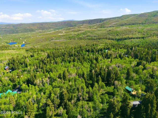 Aerial view capturing nearby mountain scenery and surrounding recreational amenities, including area lakes and open mountain terrain.
