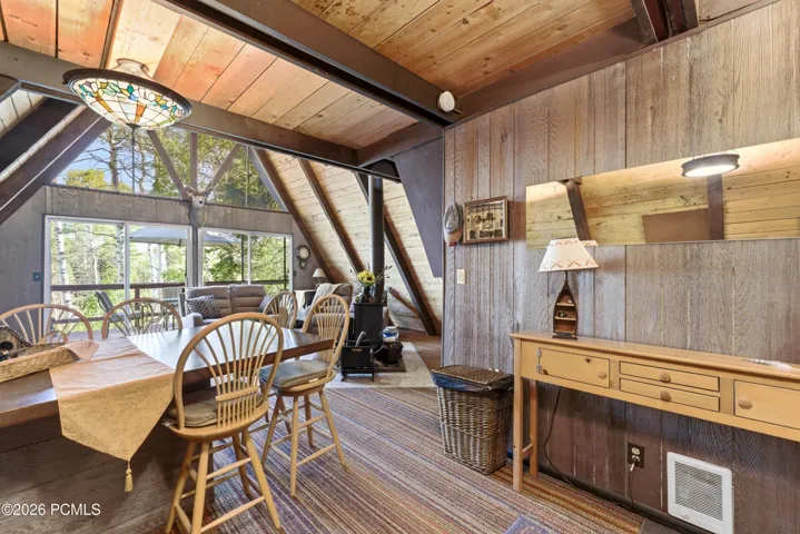 Rustic A-frame cabin dining room with wood table, Windsor chairs, pendant light, and cabin decor in Timberlake, Utah