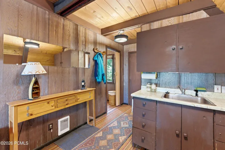 A-frame cabin kitchen with wood cabinets, sink, countertop, and gas stove in Timberlake, Utah