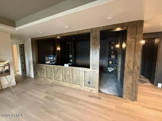Wood-finish flooring throughout, recessed ceiling lighting, and a tray ceiling detail