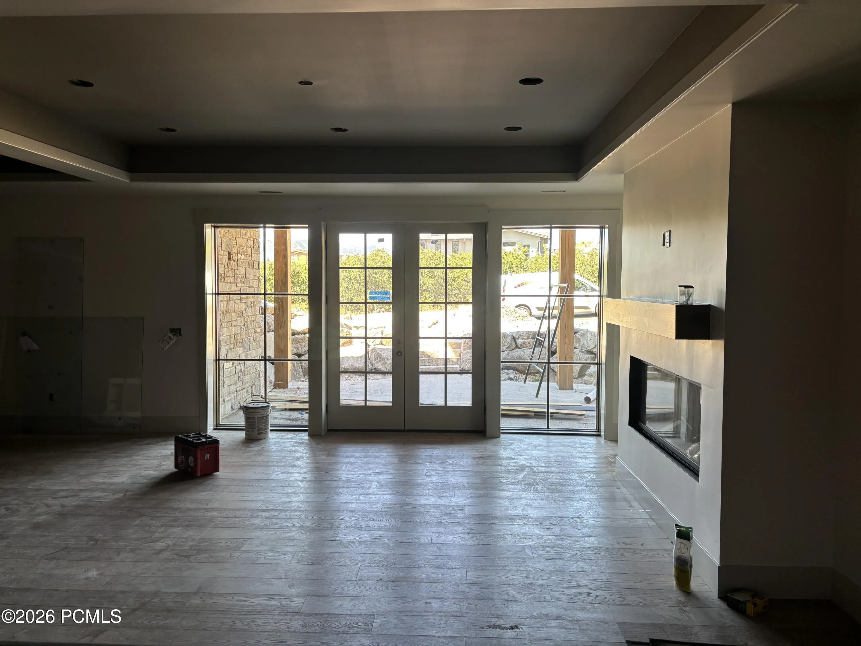French doors opening to the covered patio, flanked by two large windows