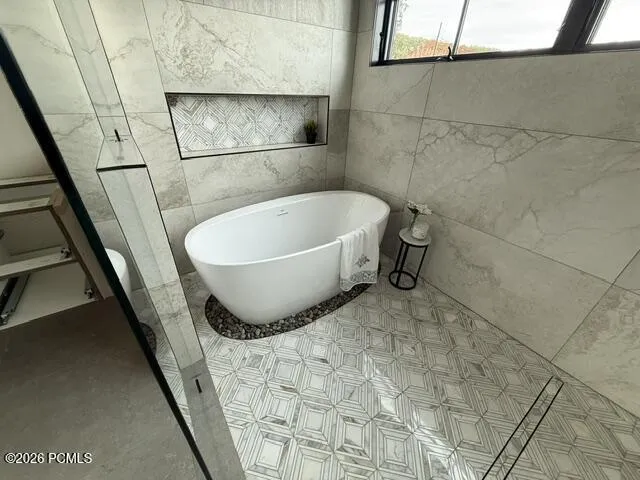 Freestanding tub set on a river rock bed