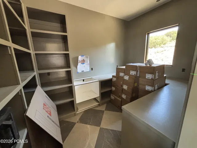 Pantry featuring checkered floor tiling, and a window letting in natural light