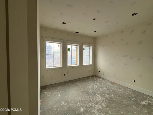 Bedroom featuring three windows