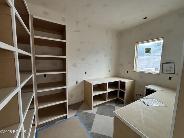 Pantry featuring checkered floor tiling, and a window letting in natural light