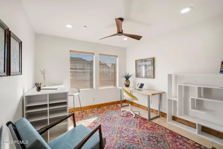 Spacious loft/office with built-in shelving, ceiling fan, and windows — flexible space perfect for a home office or third bedroom option in this Park City townhome with nightly rental allowance.