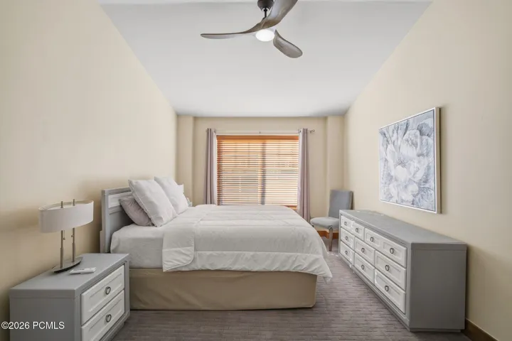 Primary suite bedroom with carpet, ceiling fan, and large windows — private retreat in this Park City townhome featuring walk-in closet, jetted tub, and double-sink en-suite bath.