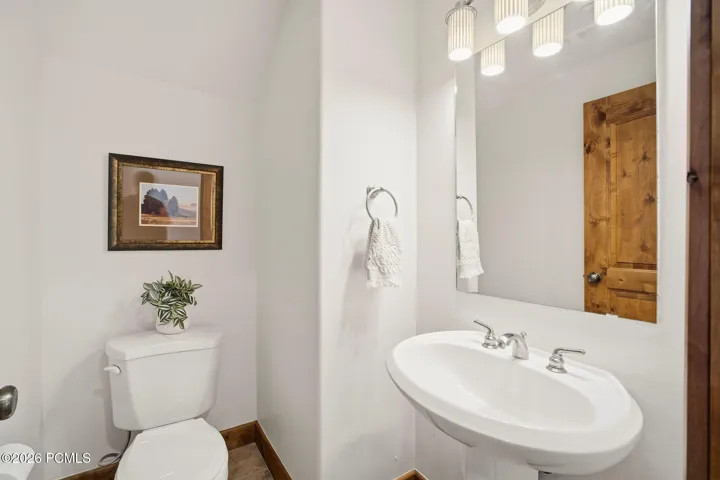 Clean powder room/half bath with pedestal sink and updated fixtures — convenient main-level bathroom in this 2-bed plus loft Park City townhome at Fox Point at Redstone.