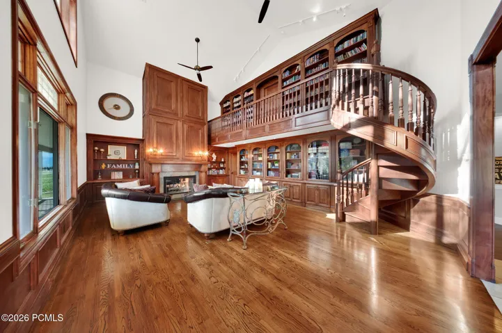 Grand living space featuring a custom-built two-story wood library with an integrated spiral staircase