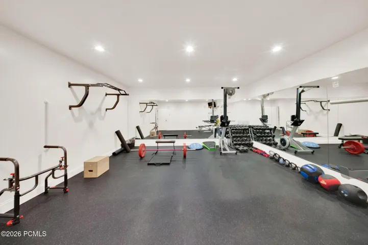 Dedicated fitness room featuring recessed lighting and extensive mirrored walls