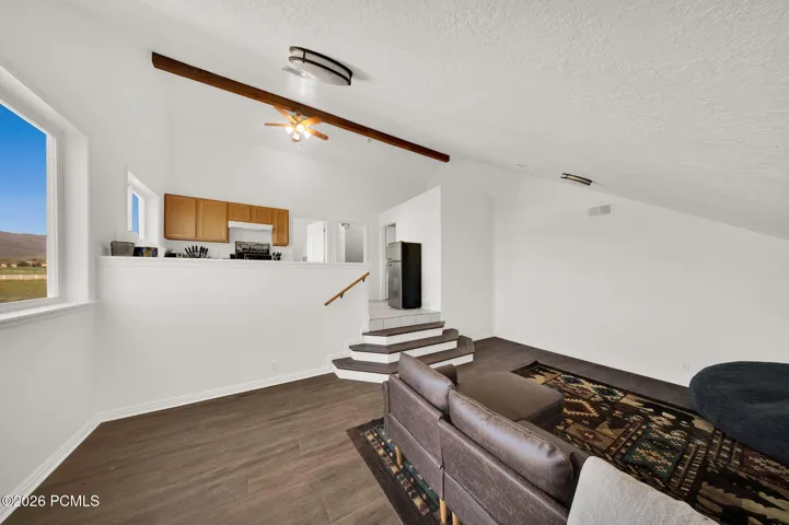 Vaulted ceiling with exposed wood beam and ceiling fan