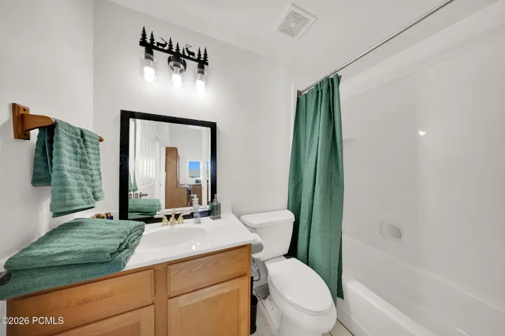 Bathroom featuring a light wood-finish vanity with a white countertop and integrated sink