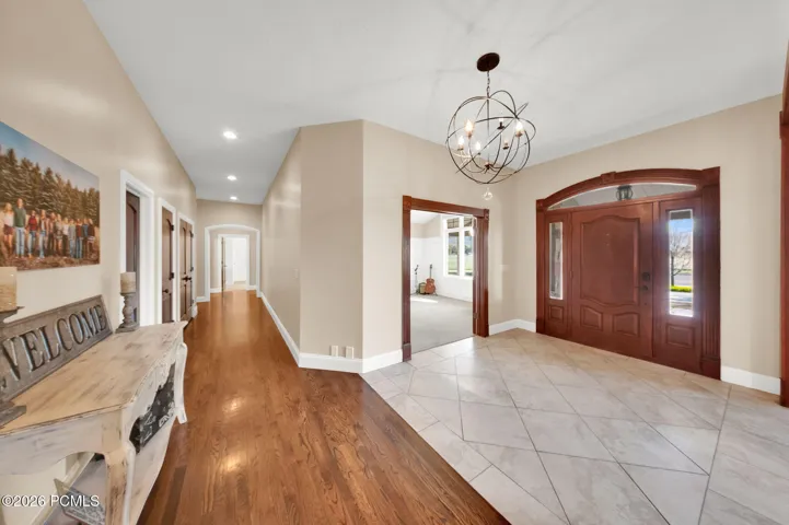 Grand entryway featuring a decorative wooden front door with sidelights