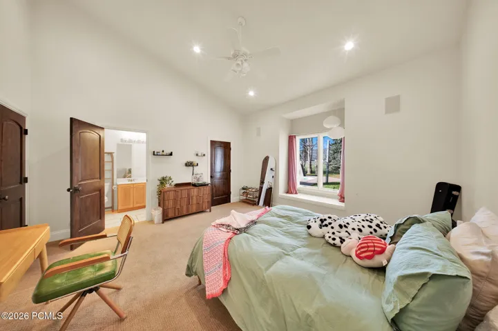 Vaulted ceiling bedroom featuring plush carpeting, recessed lighting, and a ceiling fan